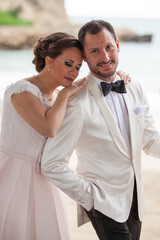 Latino Bride with eyes closed and groom with white tuxedo  looking at the camera (close up)