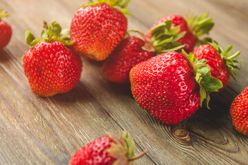 Large ripe strawberries on an old wooden table.
