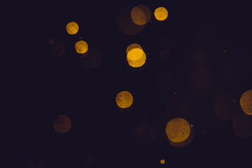Dark Abstract Gold bokeh sparkle on black background