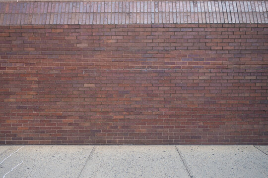 red brick and cement wall with concete cement walkway sidewalk