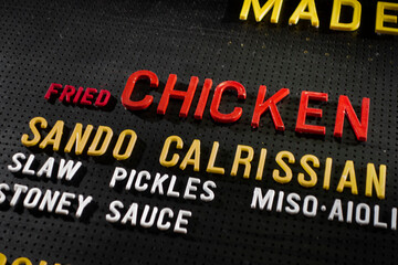 Overhead black meau board with plastic colorful letters