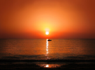 Sunrise sunset golden sun light sea horizon with motor boat silhouette shoreline
