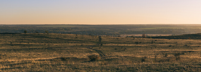 Obraz premium Ground road in the field leading to the old village