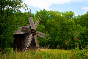 Fototapeta na wymiar wooden windmill on the plain behind the house