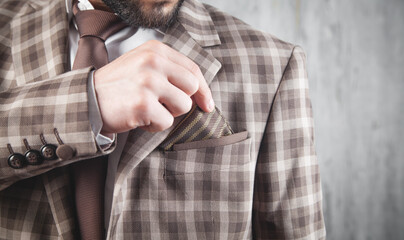 Businessman wearing brown tie and jacket standing in office.