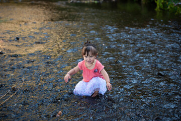little girl playing on the water on pink