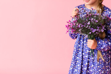 Young tender girl in blue dress, holding bouquet of beautiful purple lavender flowers isolated on bright trending pink background. International Women's Day holiday concept.