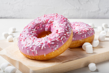 Fruit doughnut on a light background. Sweet marshmallow doughnut on a wooden Board.