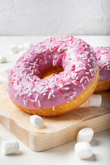 Fruit doughnut on a light background. Sweet marshmallow doughnut on a wooden Board.
