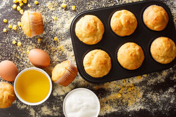 Homemade vegetarian corn muffins in a baking dish and ingredients close-up on the table. horizontal top view from above