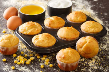 Healthy corn muffins in a baking dish and ingredients close-up on the table. horizontal - obrazy, fototapety, plakaty