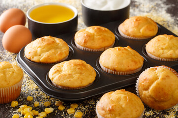 Homemade vegetarian corn muffins in a baking dish and ingredients close-up on the table. horizontal