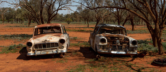 Two abandoned rusty cars somewhere in the Australian Outback
