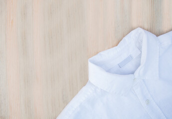 men's white shirt made of natural fabric on a wooden background