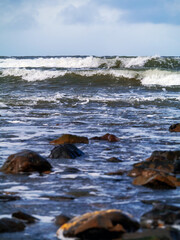 Ocean waves in focus, foreground out of focus. Simple seascape, nobody, vertical image.