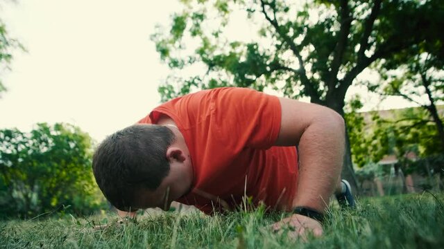 Fat male trying to do push up exercise at park, weak muscles, lack of motivation, street fitness self-isolation training