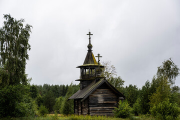 wooden ancient church on the island among the trees during the rain