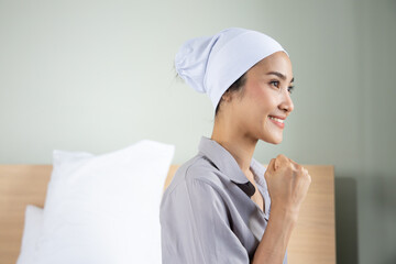 strong asian woman cancer patient recovering from sickness, wearing head scarf to cover hair loss and pain