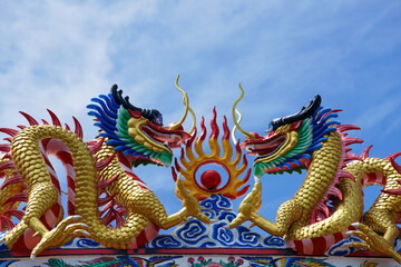 Fototapeta na wymiar dragon statue on roof against blue sky