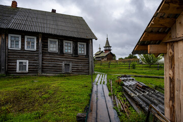 landscape with rustic wooden houses of a very old construction against the background of a gray northern sky