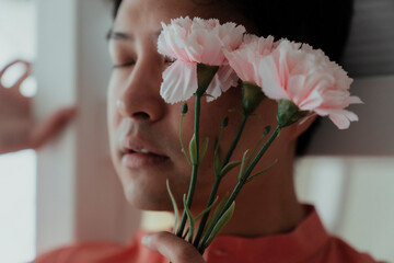 Cropped image of pink carnation in the gay's hand.