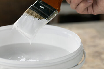 Brush in hand ready to paint with white acrylic paint