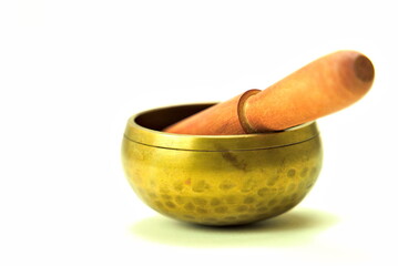 Bronze meditation singing bowl with wooden stick isolated on white background.