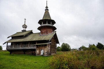 wooden ancient church on the island among the trees during the rain