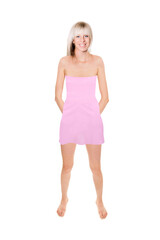 Full length portrait of a cheerful blonde woman wearing a short pink summer dress, isolated in front of white background