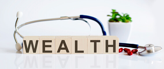 WEALTH the word is written on wooden cubes and sthetoscope and piils . Medical concept