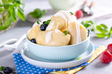 Russian, Ukrainian or Polish dish: varenyky, vareniki, pyrohy. Dumplings, filled with cottage cheese and served with sour cream.