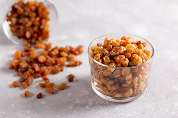 Dried and wet raisins in a glass beaker