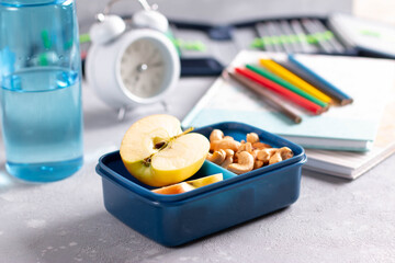 School lunch box and education stationery on table.
