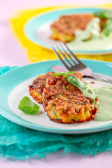 Zucchini and carrot pancakes with green sauce.