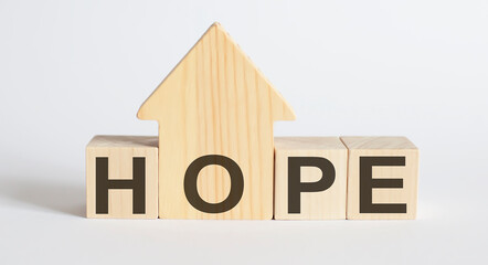 Wooden blocks with the word HOPE , house. The concept of the high cost of rent for an apartment or home.