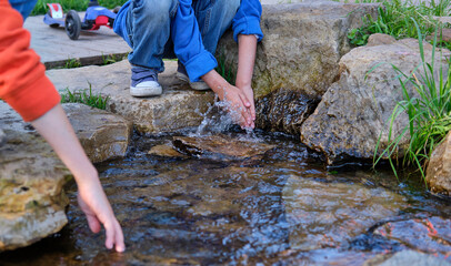 Obraz premium hand washing spring. children play with water