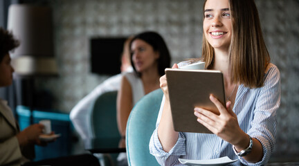 Attractive businesswoman using a digital tablet while sitting in cafe