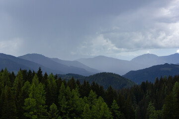 Obraz premium Mountain range in the Alps with local thunderstorm and rain shower in the distance