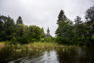 wooden ancient church on the island among the trees during the rain