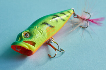 Fishing equipment. One plastic Wobbler close-up on blue background
