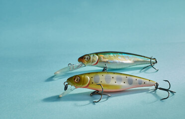Fishing equipment. Two multi-colored plastic fishing wobblers on a blue background