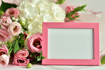bouquet of delicate roses, eustoma, hydrangea and photoframe on light background.Flowers composition.Mother's Day, Valentine's Day,birthday. Copy space. I love you concept.Wedding invitation.