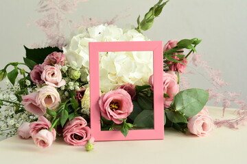 bouquet of delicate roses, eustoma, hydrangea and photoframe on light background.Flowers composition.Mother's Day, Valentine's Day,birthday. Copy space. I love you concept.Wedding invitation.