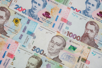 Background from the new banknotes of the Ukrainian hryvnia. Ukrainian money. A bill of one thousand hryvnia, five hundred and two hundred hryvnia and twenty hryvnia lying side by side.