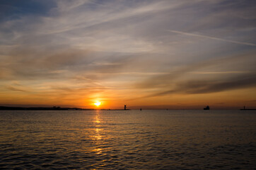 NAVIGATION SIGN ON THE BREAKWATER AND SHIP - Sunset on the seashore in Swinoujscie