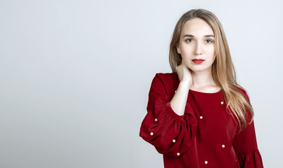 Picture of stylish young woman keeping hand on neck. Copy space for your text