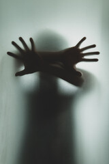 Ghost concept shadow of a men behind the matte glass blurry hand and body soft focus
