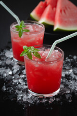 Summer cold drink with watermelon and mint on a black wooden background..