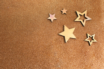 Fototapeta na wymiar Rose gold stars and glitter on light brown background