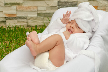 Obraz na płótnie Canvas Bebé recién nacido en sesión de spa al aire libre, relajado y disfrutando envuelto en toallas.